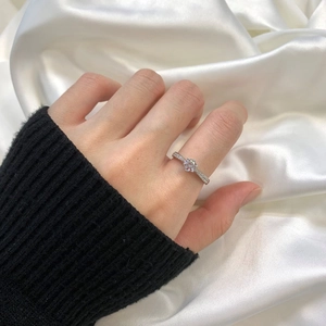 Macro detail of classic S925 silver six-prong ring with sparkling solitaire and micro-pave diamonds