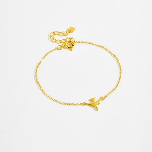 Macro shot of S925 sterling silver gold-plated airplane pendant on a fine link bracelet