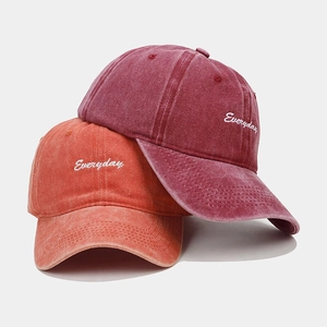 Detail of vintage washed cotton baseball caps with Everyday embroidery in wine and orange