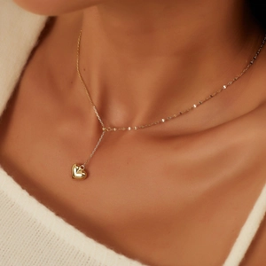 Elegant gold S925 silver Y-shaped necklace with heart pendant on white sweater