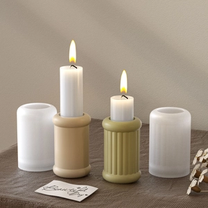 Close-up of anchor striped cylindrical resin candle holders with warm burning flames