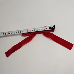 Close-up of red velvet Christmas bow with measuring tape showing 23cm length detail