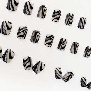 Matte black and white zebra pattern press-on nails with silver glitter wavy line details