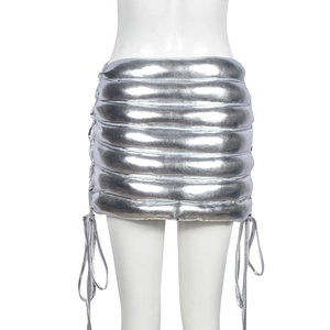 Close-up of metallic silver quilted mini skirt featuring adjustable side lace-up detail