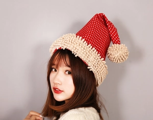 Detail of red Christmas hat with white stars and beige plush texture worn by a model