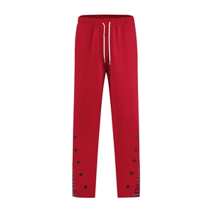 Détail du jogging rouge avec boutons-pression latéraux et doublure intérieure à carreaux