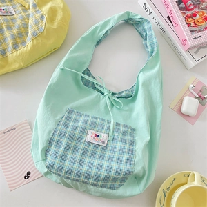 Detailed top view of a mint green summer plaid tote bag with artistic lifestyle props