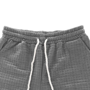 Close-up of gray waffle texture fabric with elastic waistband and woven drawstrings
