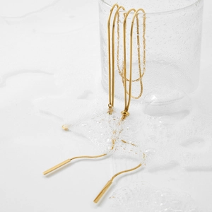Gold stainless steel Y-shaped snake chain necklace with bar pendants on glass rim