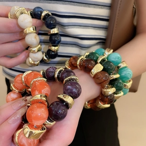 Detail view of colorful acrylic marble beads with gold irregular metal spacers on wrist