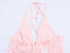 Détail du haut licou rose avec appliqués floraux 3D, perles centrales et décolleté en V profond