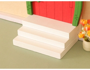 Close-up of white wooden miniature three-step stairs for dollhouse Christmas DIY scenes