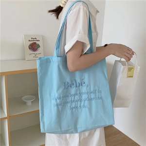 Detailansicht der hellblauen Canvas-Tragetasche mit dunkelblauer Stickerei für Damen