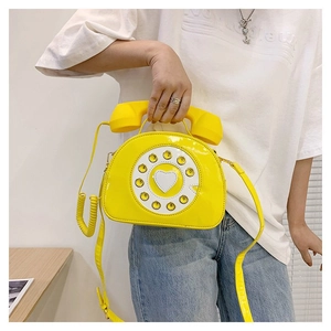 Detail of yellow retro telephone crossbody bag with rotary dial and handset handle