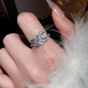 Vista dettagliata di un anello a piuma d'argento con zirconi su una mano femminile