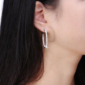 Silver hoop earrings for women with white zircons shown on a model close-up