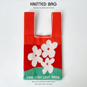 Close-up of vibrant floral knitted handbag with You Only Live Once text embroidery