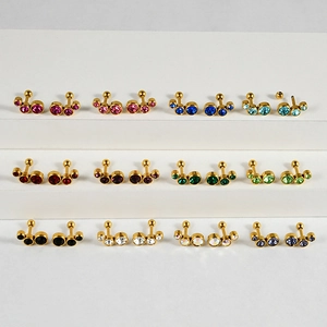 Vue détaillée de clous d'oreilles CZ multicolores avec sertissage en acier doré
