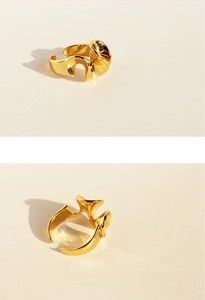 Macro detail of glossy golden wavy irregular geometric adjustable open ring surface