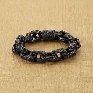 Macro view of vintage stainless steel chain bracelet with intricate floral engravings