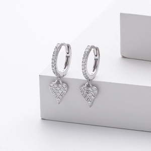 Macro detail of silver heart drop earrings with shimmering cubic zirconia pavé