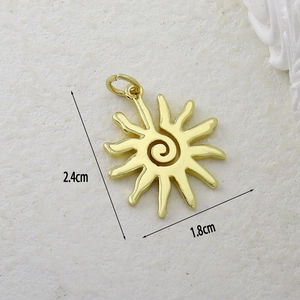 Macro shot of gold sun pendant with cubic zirconia inlay and 2.4cm x 1.8cm dimensions