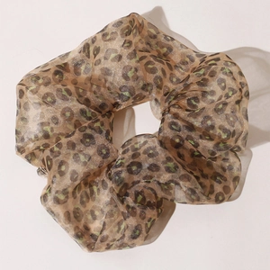Detailed view of leopard print chiffon scrunchie with subtle shimmer and translucent texture