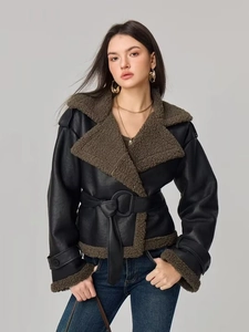 Detail of faux leather jacket with brown shearling collar and waist-cinching belt