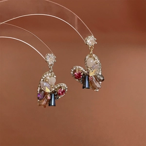 Close-up of heart crystal earrings with zircon inlay on a transparent curved stand