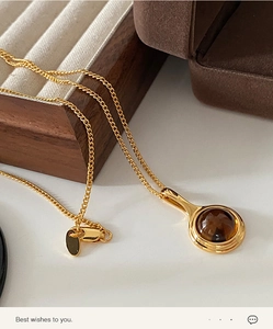 Detailed macro view of the oval smoky quartz pendant on a delicate gold lobster clasp chain