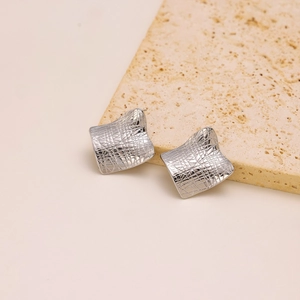 Irregular silver geometric square earrings with 3D mesh texture on a stone base