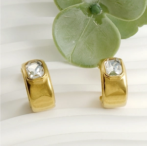 Détail des boucles d'oreilles en C plaquées or 18 carats avec zircon sur fond blanc
