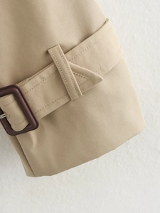 Macro detail of khaki twill trench coat fabric with stitching and square buckle