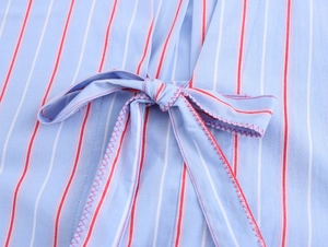 Close-up of bow tie detail on light blue vertical striped shirt with red stitching
