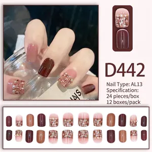 Détails macro des faux ongles D442 avec perles et motif à carreaux style français