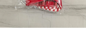 Detail view of red and white striped knit Christmas stocking in transparent packaging