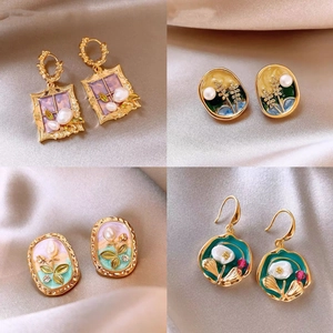 French vintage gold-plated pearl flower earrings set on champagne silk fabric background