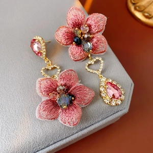 Détails de boucles d'oreilles vintage asymétriques avec fleurs roses et motifs de cœur