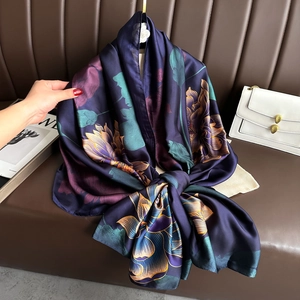 Detailed view of dark faux silk scarf with golden lotus print showing elegant drape