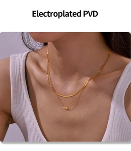 Détail d'un collier double épaisseur doré PVD avec perle porté par un mannequin