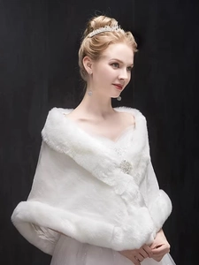 Detail of white faux fur bridal shawl featuring a plush collar and sparkling crystal brooch