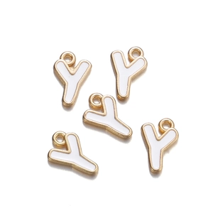 Detail of five gold-framed white enamel letter Y pendants for DIY jewelry making