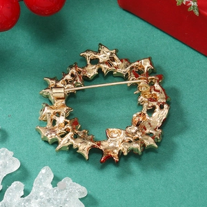 Detailed back view of a gold Christmas wreath brooch with a sturdy pin clasp on holiday decor