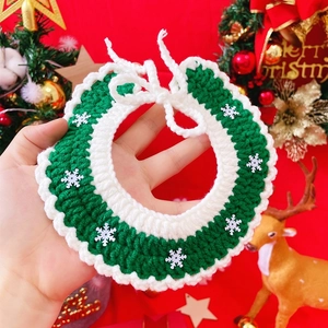 Detail of green and white knit pet Christmas collar with snowflake and bell decor