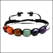 Detail of bohemian adjustable woven bracelet featuring seven natural chakra healing stones