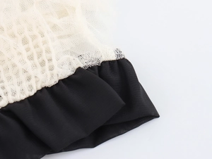 Détail macro du tissu en maille blanche avec coutures contrastées sur chemisier français