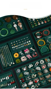 Macro detail of emerald green velvet jewelry tray featuring ring slots and necklace dividers