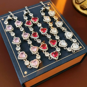 Detailansicht der Silberarmbänder mit rosa, roten und weißen herzförmigen Edelsteinen