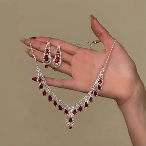 Detail of luxury teardrop red gemstone jewelry set with diamond fringe necklace and earrings