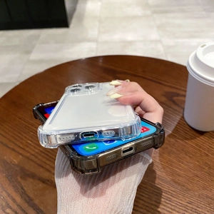Detailed view of clear shockproof phone cases with reinforced corners on a wooden table